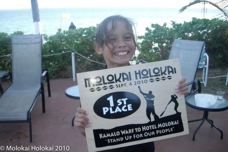 A keiki holds a first-place sign
