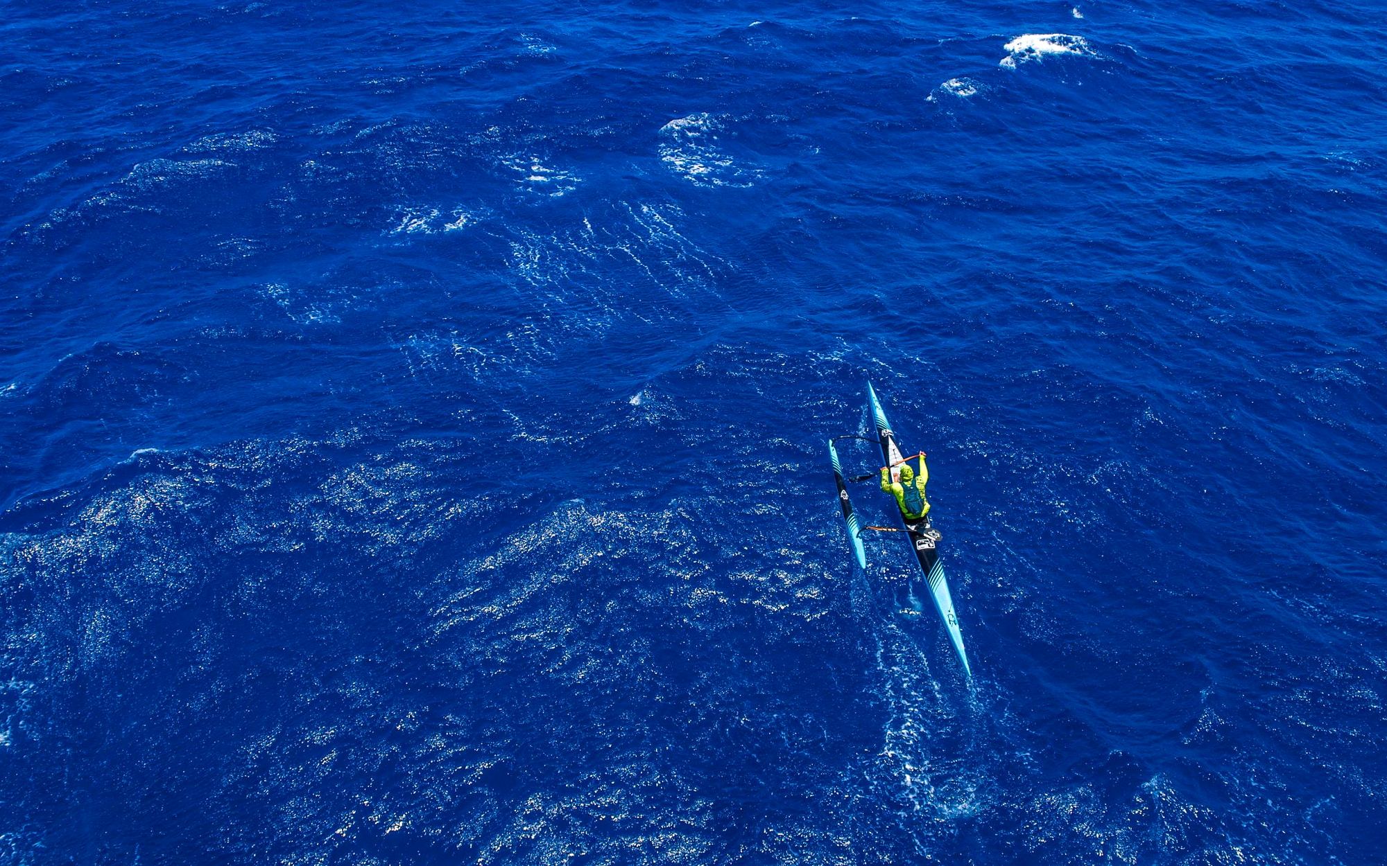 Aerial view of a paddler crossing the deep blue Pailolo Channel