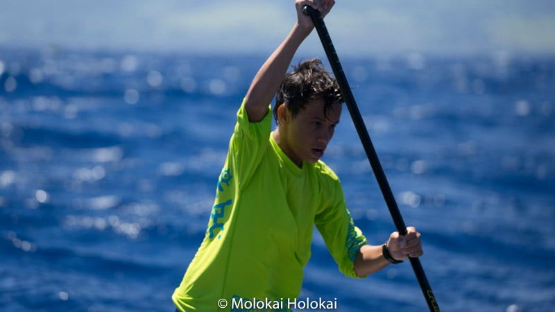 A young paddler digs in on a stand-up paddleboard