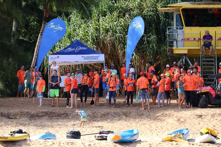 Racers in orange shirts gather at the Maui start line