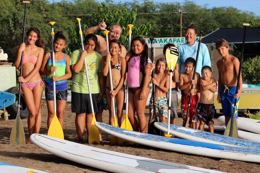 Keiki holding paddles next to paddleboards